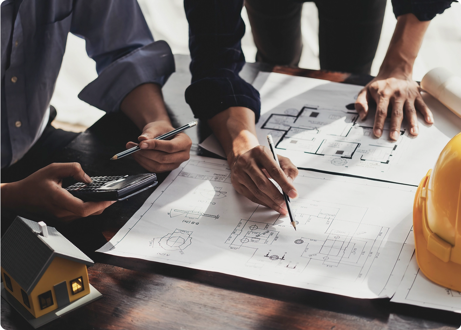 Architects reviewing building plans with tools.